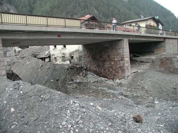 A közúti híd az árvizet visszaduzzasztotta, fokozva ezzel a pusztítást a felette lévő partszakaszon 